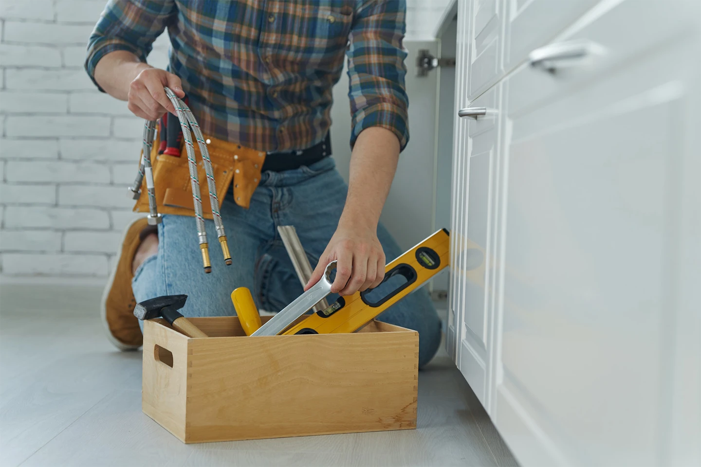 Close up of handyman preparing tools to repair kitchen sink