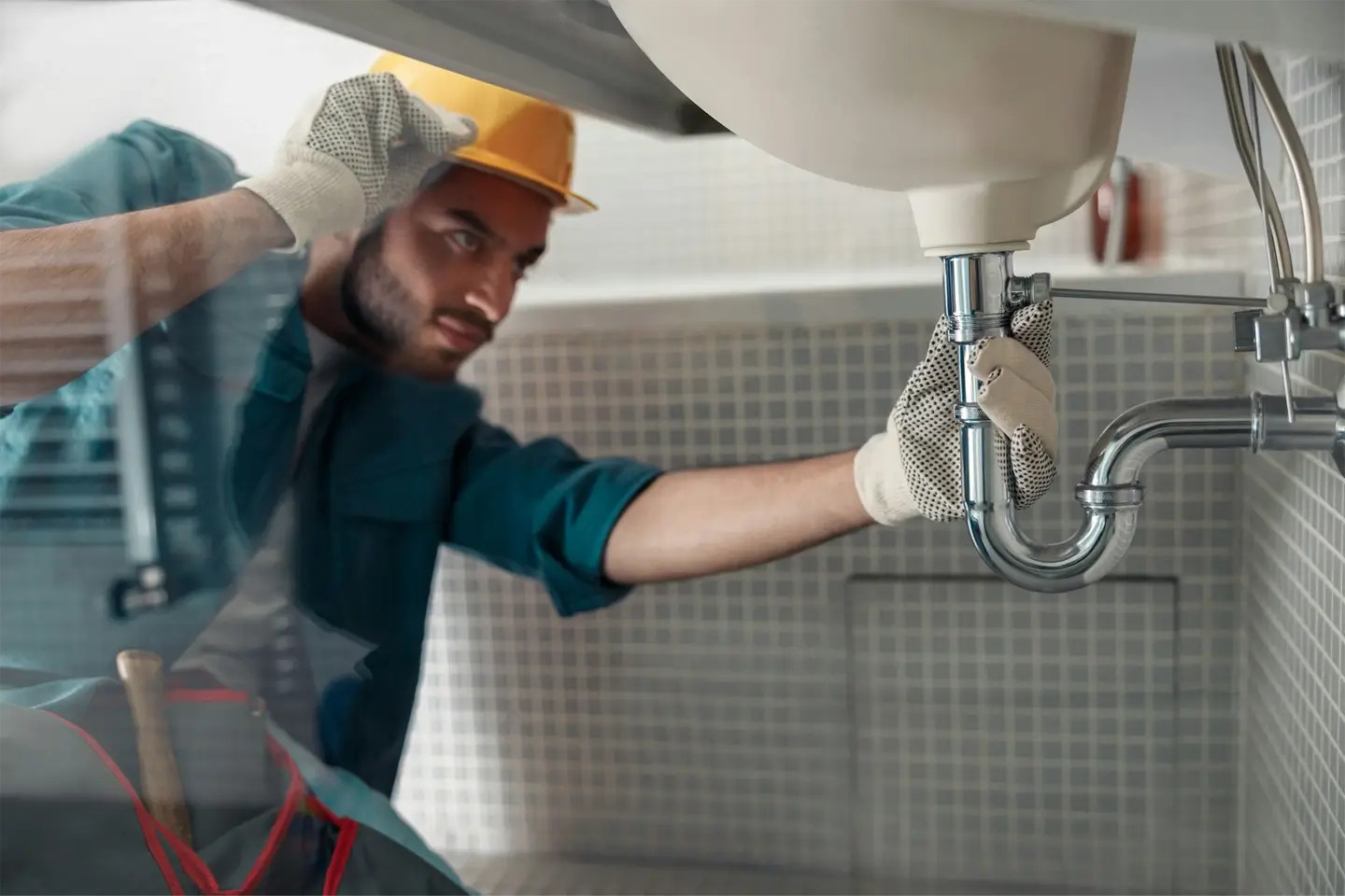 Male plumber is repairing faucet of a sink at bathroom good quality plumbing company service